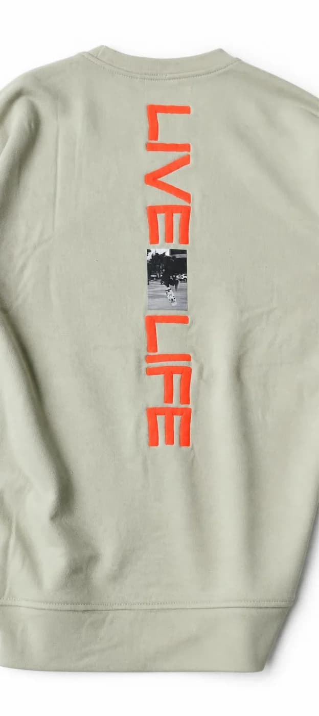 Sage crewneck sweatshirt with an orange Live Life print down the back